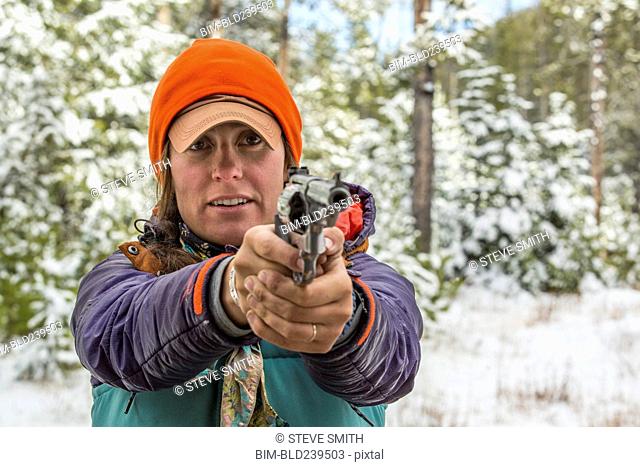 Caucasian woman aiming handgun in winter