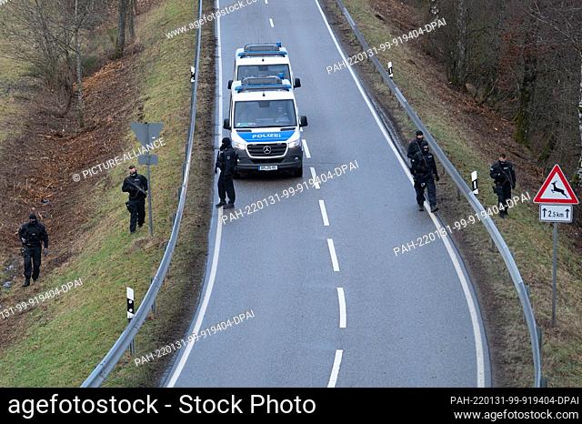 31 January 2022, Rhineland-Palatinate, Mayweilerhof: Police officers search the road on County Road 22 about a kilometer near the scene where two police...