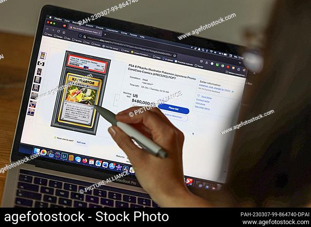 06 March 2023, Berlin: A woman points to the card on her laptop at an eBay auction. For 480, 000 dollars, the card Japanese ""Pikachu Illustrator"" from the...