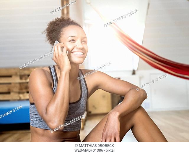 Happy young woman in sportswear on cell phone