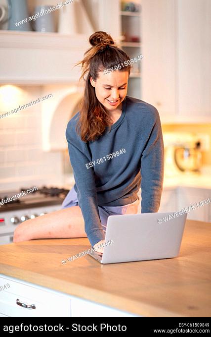 Woman using laptop in the kitchen