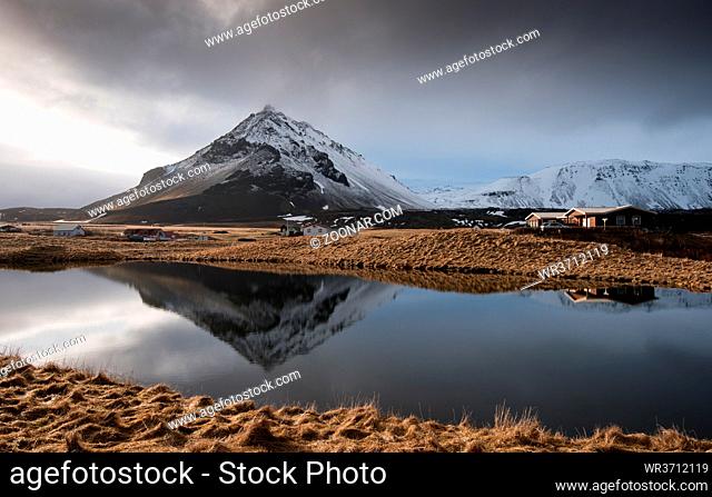 Typical Icelandic dramatic winter landscape with lake and mountains covered with snow in Arnarstapi area in iceland