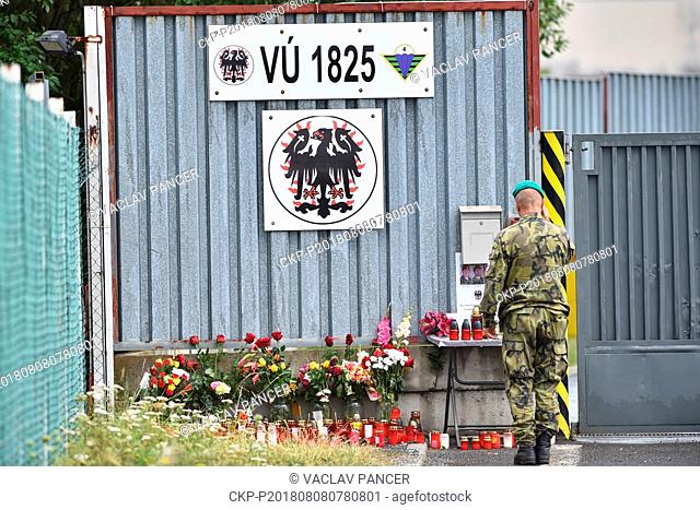 People lay flowers and lit candles by entrance to a base of 42th Mechanized Battalion in Tabor, Czech Republic, on August 6, 2018