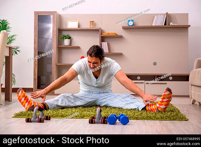 Young man doing sport exercises indoors