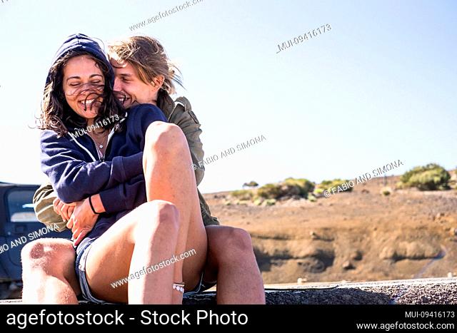 Beautiful young caucasian people in couple have fun and laugh together in outdoor leisure activity - concept of relationship and love for youth and cute models