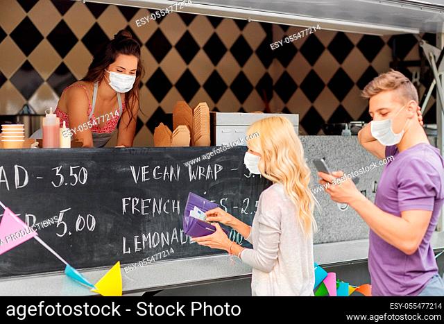 seller and customers in masks at food truck