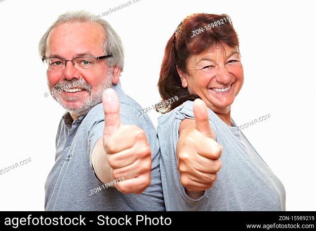 Zwei lachende zufriedene Rentner halten ihre Daumen hoch