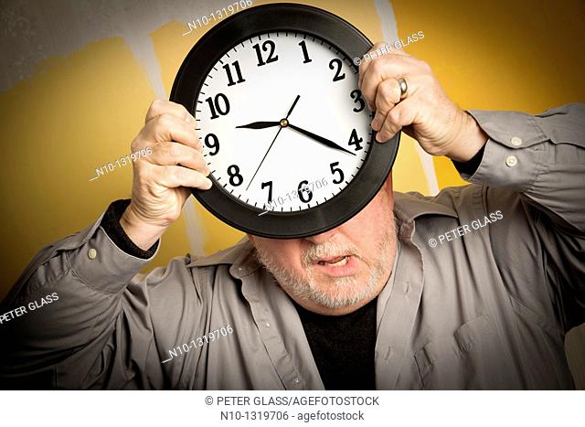 Middle-age balding man holding a clock