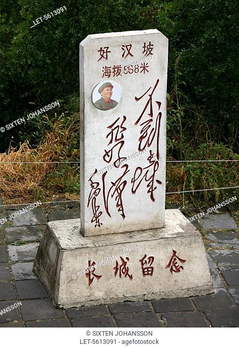 Commemorative stone with chairman Mao's picture by the great wall. China
