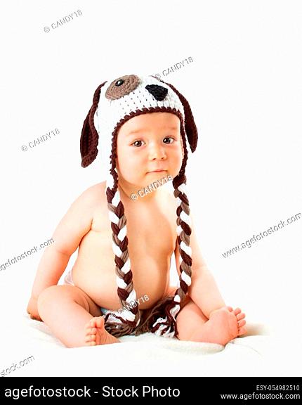 cute baby in dog hat sitting isolated on white background