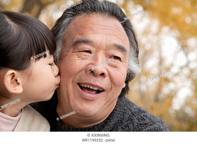 A girl kissing her grandfather