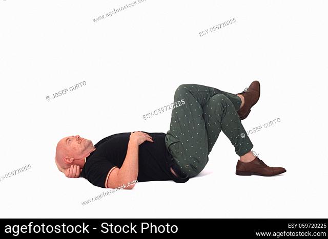 side view of pensive man lying on a floor on white background