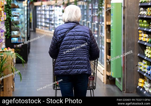 31 March 2022, Bavaria, Neubiberg: A woman walks through a supermarket with her shopping cart. On 04.04.2022 the mask obligation in the supermarket is to be...