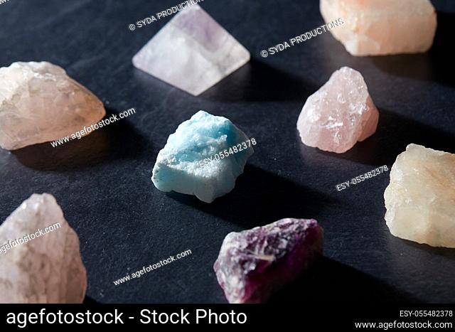 quartz crystals and gem stones on slate background