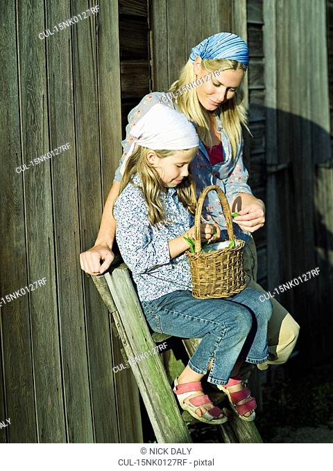 A woman and girl with a basket of beans