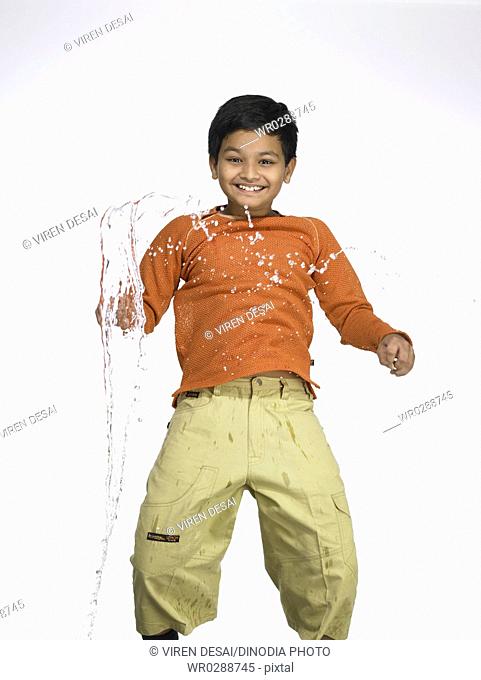 Water splashing on South Asian Indian boy in nursery school MR