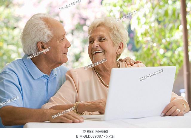 Senior Hispanic couple using laptop together