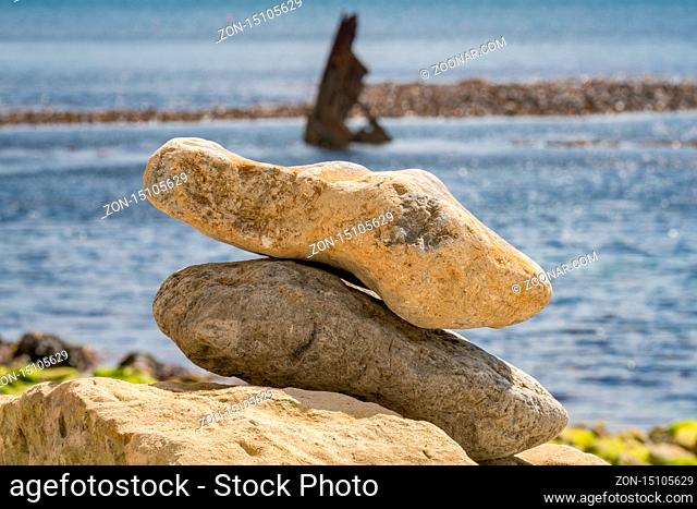 Stones at Osmington Bay, with the Wreck of the Mix in the background, Osmington Mills, near Weymouth, Jurassic Coast, Dorset, UK