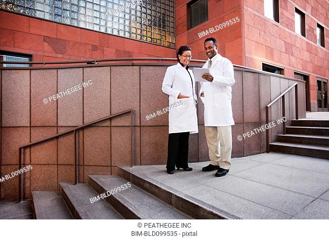 Doctors using digital tablet outdoors