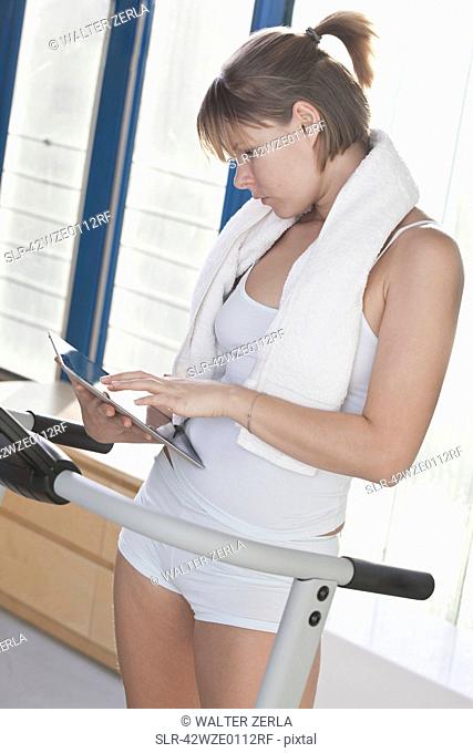Woman using tablet computer in workout