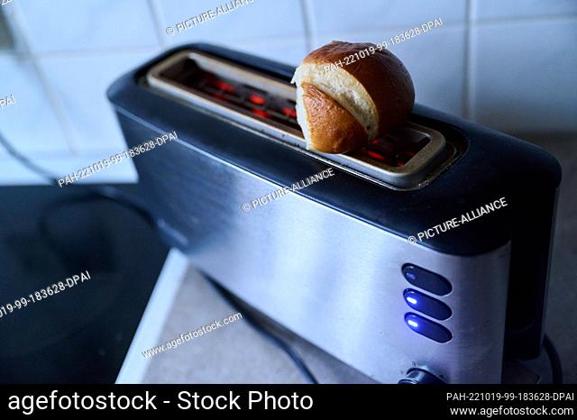 PRODUCTION - 18 October 2022, Berlin: A roll lies on a toaster, which heats. Photo: Annette Riedl/dpa. - Berlin/Berlin/Germany