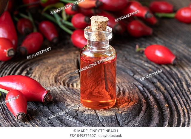 A bottle of rosehip seed oil with fresh berries