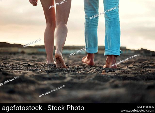 Close up and legs view for man and woman walking together on the ground in barefoot natural style. Concept of love and life together. Nudism