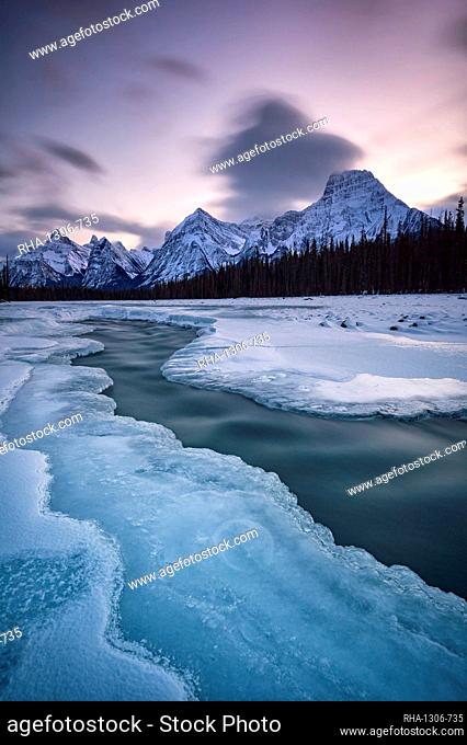 The Athabasca River in winter with mountain backdrop, Alberta, Canada, North America