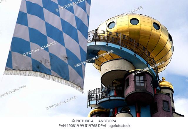 19 August 2019, Bavaria, Abensberg: Next to the 35 meter high Hundertwasser Tower hangs a blue-white chequered flag. The tower is one of the last projects...