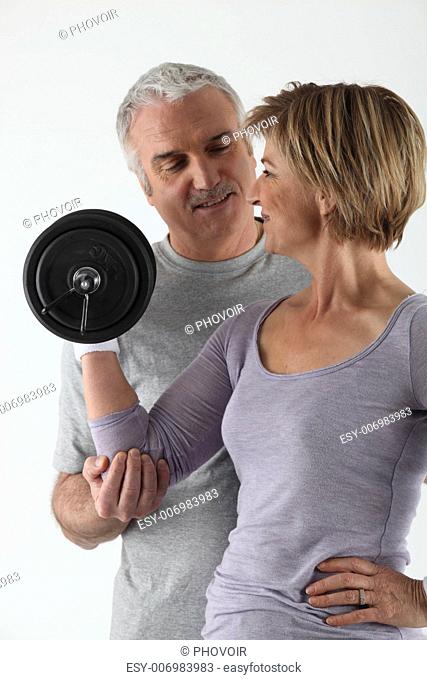 Mature couple practicing fitness on white background