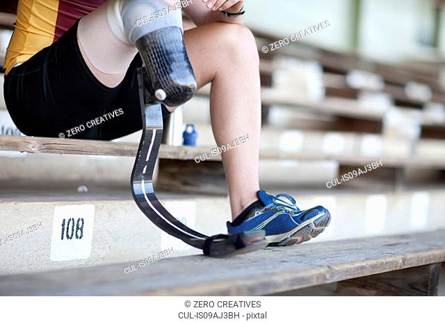 Sprinter sitting with prosthetic leg on