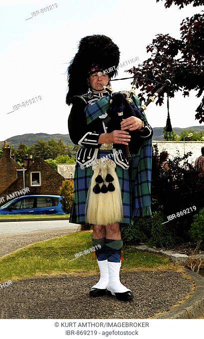 Bag piper in traditional Scottish Clan attire and kilt, nearby Loch Ness, Scotland, United Kingdom