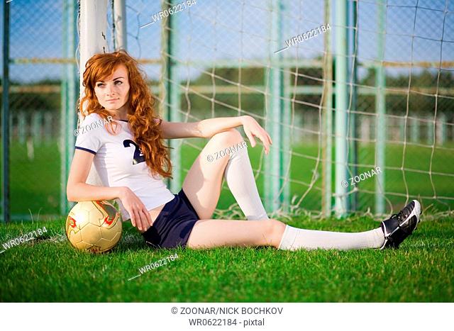 Healthy beautiful girl with freckles on soccer field