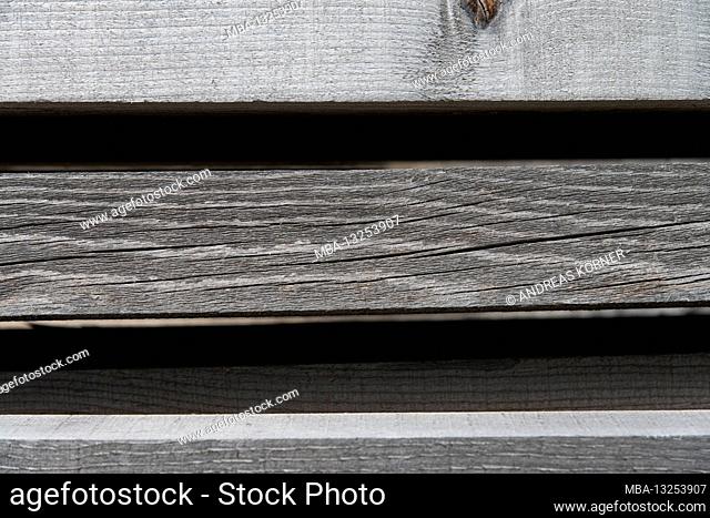 Faded, parallel wooden slats against a black background