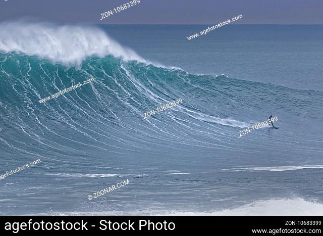 Surfer in einer Welle, Nazare, Portugal, Europa / Surfer on surf board riding wave, Nazare, Portugal, Europe