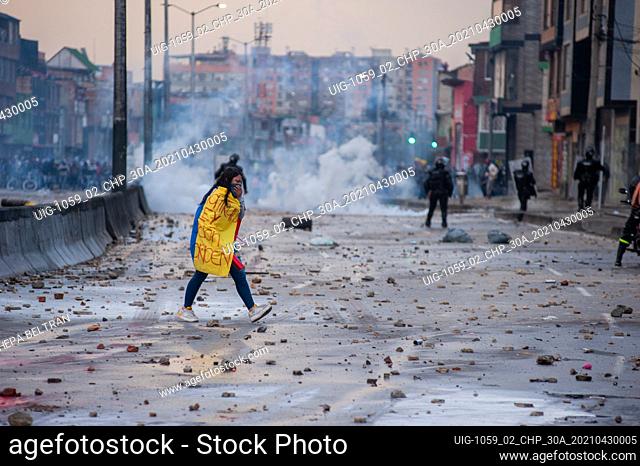 A demonstrator passes behind the clashes between ESMAD and Demonstrators using a Colombian Flag in Bogota, Colombia clashes happened soon after demonstrators...