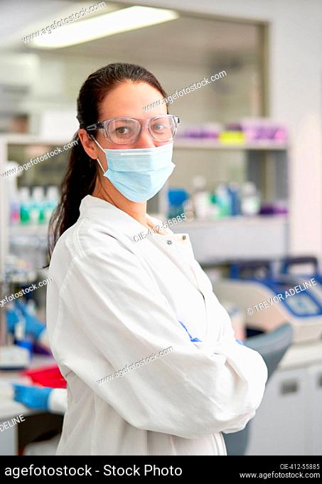 Portrait confident female scientist in face mask and goggles