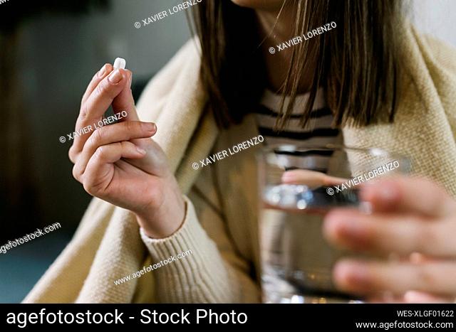Woman taking medicine at home