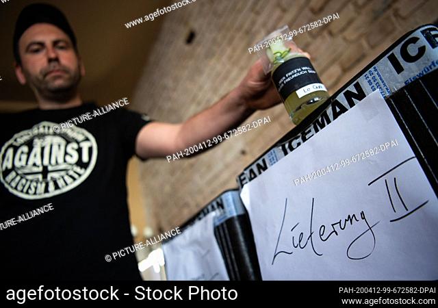 08 April 2020, Brandenburg, Potsdam: Ronny, one of the two managing directors of the ""Bar Fritz'n"" in Dortustraße, places a glass bottle with the cocktail...