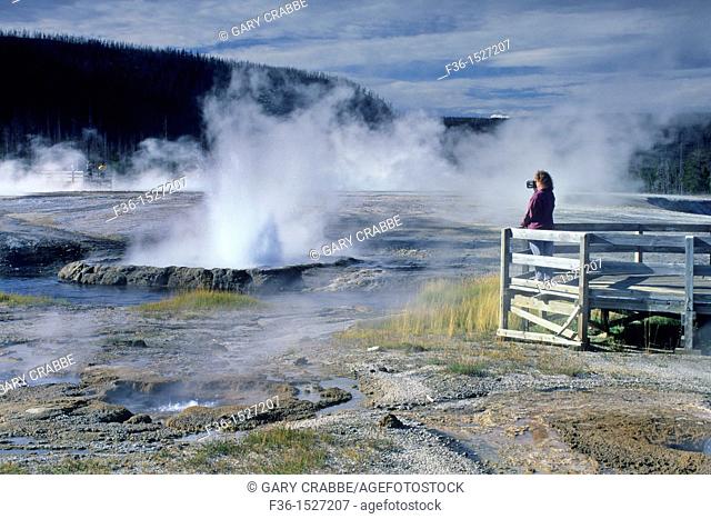 Tourist at boardwalk over look at Cliff Geyser, Black Sand Basin, Yellowstone National Park, WYOMING
