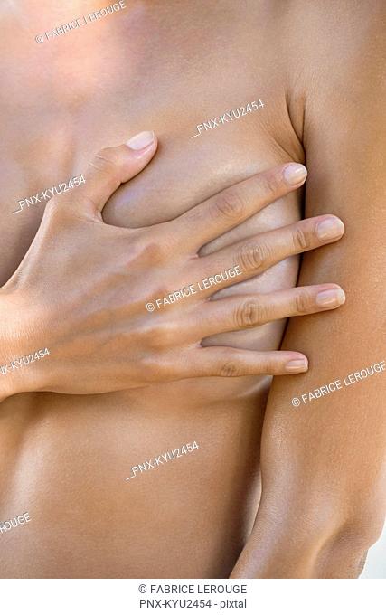 Close-up of a woman hiding her breast with her hand