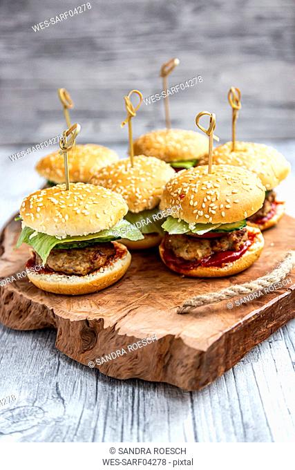 Mini-Burger with mincemeat, salad, cucumber and tomato on wooden tray