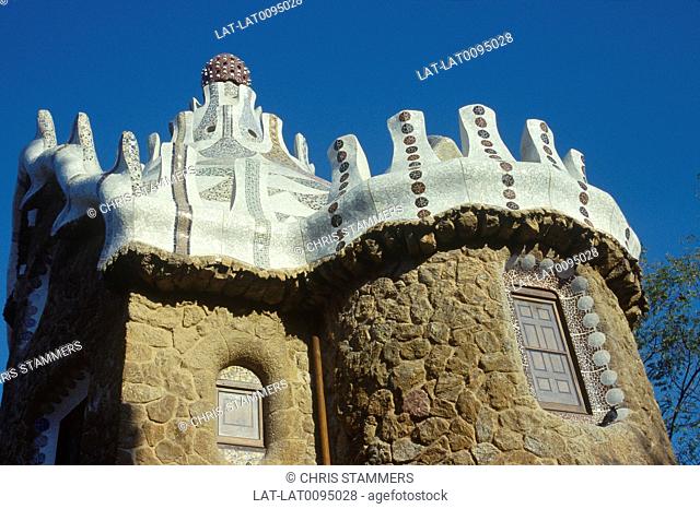 Parc Guell. Gaudi art, architecture. Entrance pavilion. Stone tower, carved stone of roof