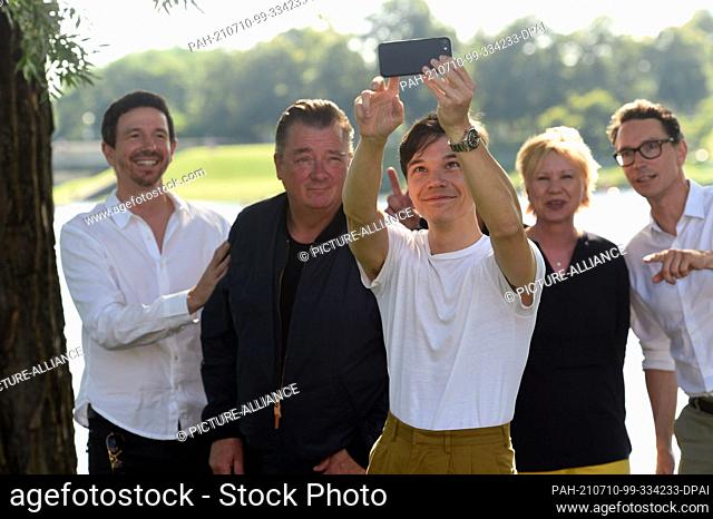 10 July 2021, Bavaria, Munich: The producer Oliver Berben, (l-r) the actor and leading actor Peter Kurth, the actor Sebastian Urzendowsky (with mobile phone)