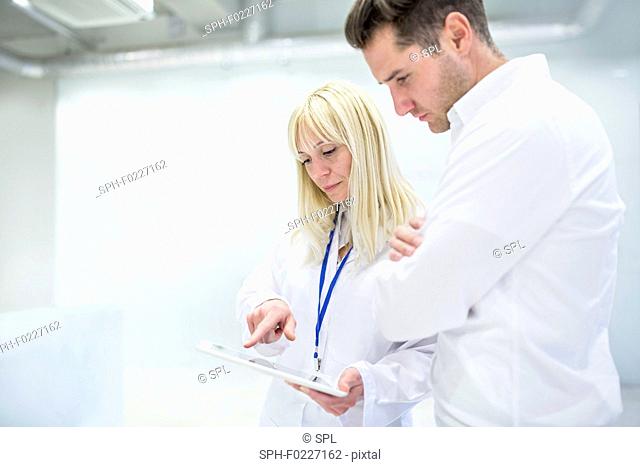 Doctor discussing medical notes on digital tablet with consu