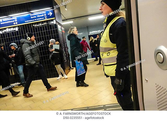 Stockholm, Sweden An information officer directs traffic at the Slussen Metro or Tunnelbana station at rush hour