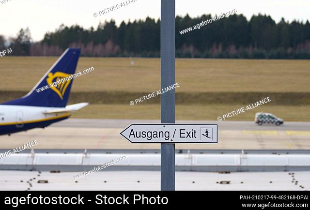 16 February 2021, Rhineland-Palatinate, Lautzenhausen: A sign ""Exit / Exit"" stands at ""Frankfurt Hahn Airport"" next to a Ryanair machine
