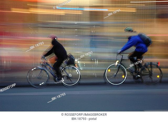Two people driving bicycle