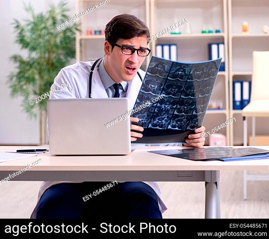 The young doctor looking at x-ray images in clinic