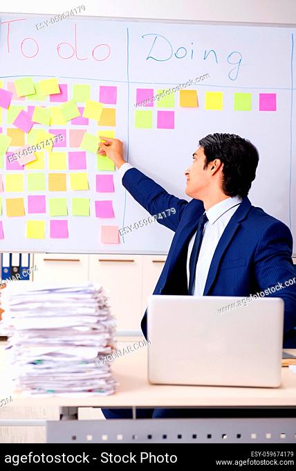 Young handsome employee in front of whiteboard with to-do list